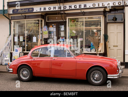 A classic Jaguar S-type parked outside an ironmonger's shop in Clare, Suffolk, England. Stock Photo