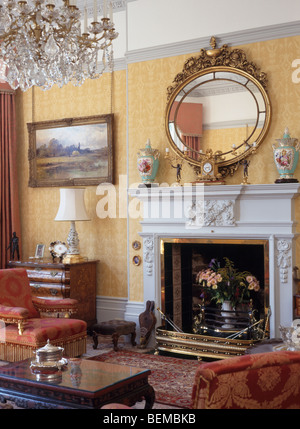 Large ornate gilt mirror above fireplace in cosy panelled country Stock ...