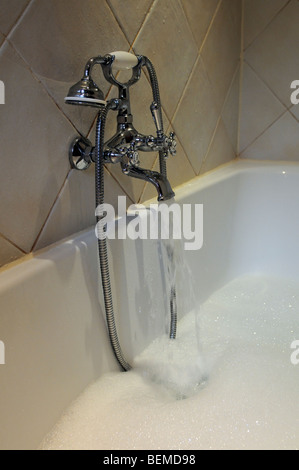 Filling a bath with hot and cold water from a mixer tap Stock Photo