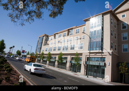 A tilted view of a building with condos and office space, viewed from a divided road. Park Broadway, El Camino Real, Millbrae Stock Photo