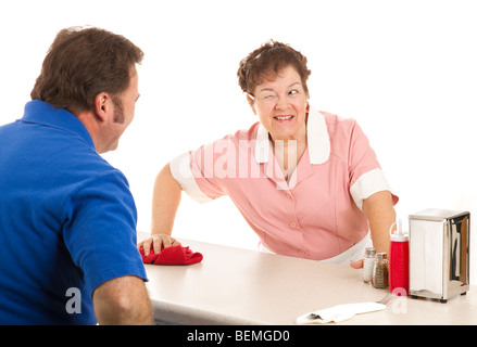 Friendly waitress winks at a customer as she wipes down the lunch counter. White background. Stock Photo