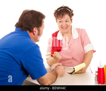 Friendly waitress taking a customer's order at a restaurant lunch counter. Isolated on white.  Stock Photo