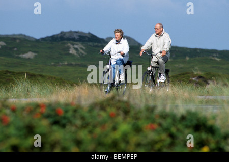 Elderly couple riding in the dunes, Belgium Stock Photo