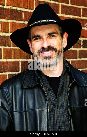Man with beard in cowboy hat and leather jacket Stock Photo