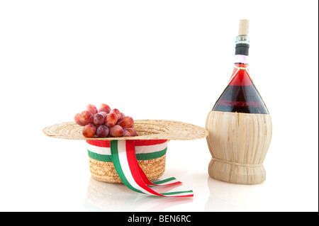 Basket bottle with Chianti grapes and hat from Italy over white Stock Photo