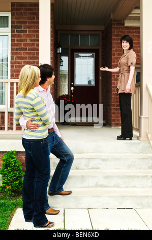 Real estate agent with couple welcoming to new home Stock Photo