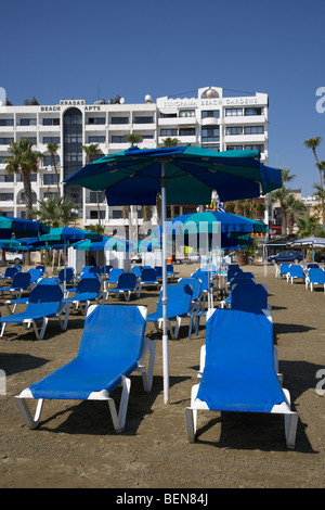 empty sun loungers in front of hotels and apartments on phinikoudes beach in the town centre of larnaca republic of cyprus Stock Photo