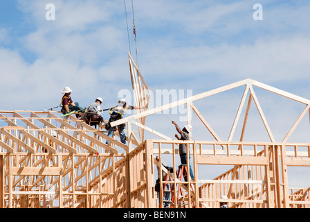 roof trusses being put in place at a construction site Stock Photo