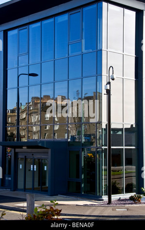 Mirrored images and reflections of tenement housing on modern office block windows in urban Dundee,UK Stock Photo