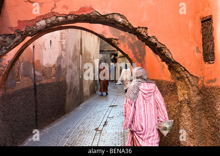 Woman dressed in traditional Islamic dress walking in the souq of Marrakech Medina, Morocco. Stock Photo