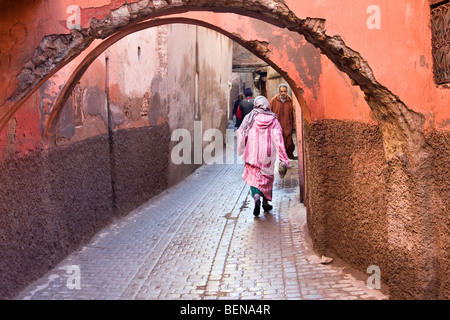Woman dressed in traditional Islamic dress walking in the souq of Marrakech Medina, Morocco. Stock Photo
