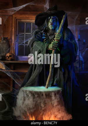 Scary old witch stirring potion in a cauldron inside her cabin on Halloween