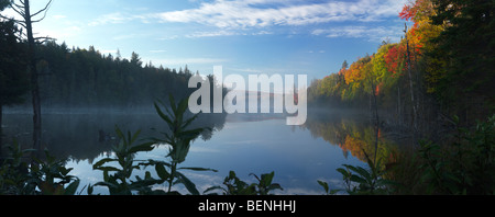 Mist over Smoke lake at dawn. Beautiful panoramic fall nature scenery. Algonquin Provincial Park, Ontario, Canada. Stock Photo