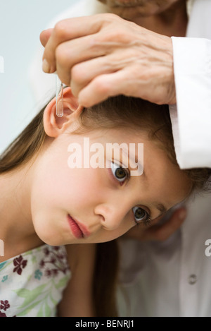 Doctor putting drops in little girl's ear, cropped Stock Photo