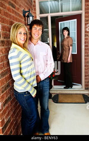 Real estate agent with couple welcoming to new home Stock Photo