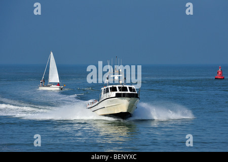 Motorboat / cabin cruiser and sailing boat on the North Sea Stock Photo