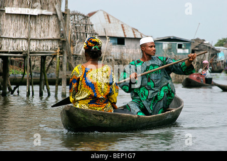 Tofinu man and woman in canoe at Ganvie, largest lake village in Africa, in Lake Nokoué near Cotonou, Benin Stock Photo