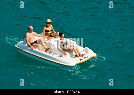 Elderly tourists in bathing suits in pedal boat on lake during the summer holidays on a hot day Stock Photo
