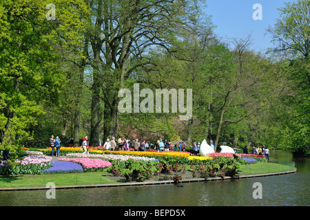 Tourists walking among colourful tulips, hyacinths and daffodils in flower garden of Keukenhof, Lisse, Holland, the Netherlands Stock Photo