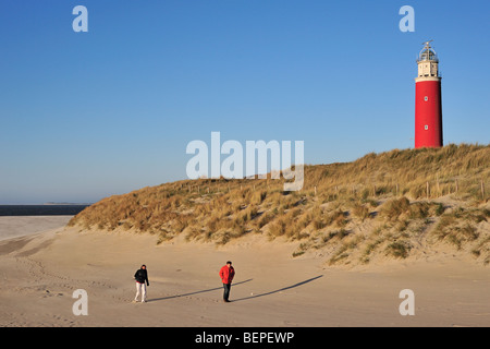 Walkers on the beach and the red Cocksdorp lighthouse Eierland in the dunes on the island Texel, the Netherlands Stock Photo