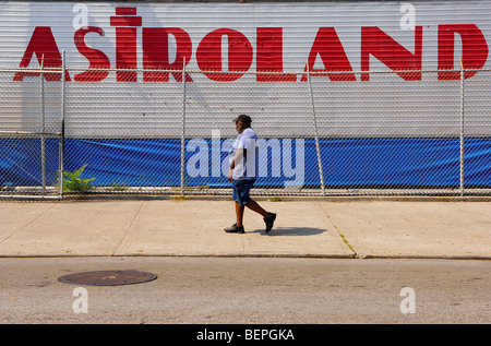 A man walks past the Astroland Park amusement park on the Coney Island Boardwalk, Brooklyn, New York. Stock Photo