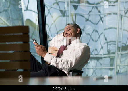 man leaning back in chair smiling Stock Photo