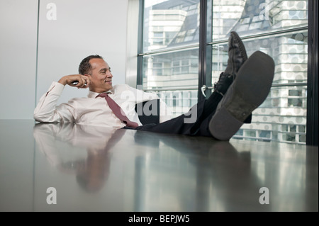 man sitting at table feet up Stock Photo