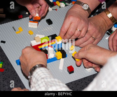 Teamwork building LEGO Stock Photo