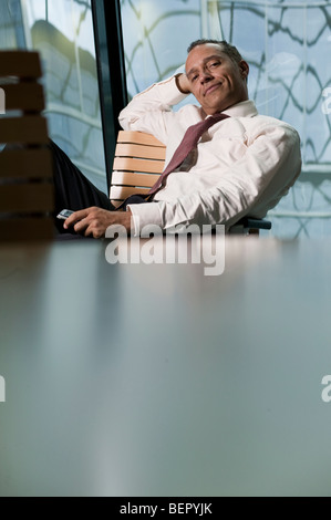 man leaning back in chair smiling Stock Photo