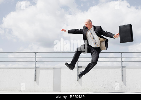 man jumping in the air with briefcase Stock Photo