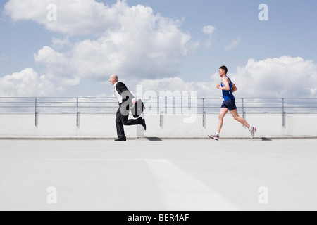 business man running from jogger Stock Photo