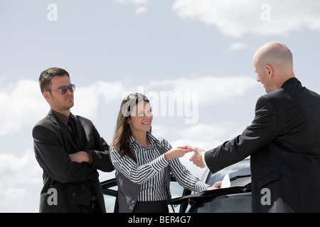 man signing contract on back of car Stock Photo