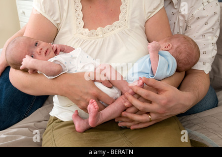 Mother cuddling identical twin baby boys, premature babies, 11 weeks old, born 10 weeks early Stock Photo