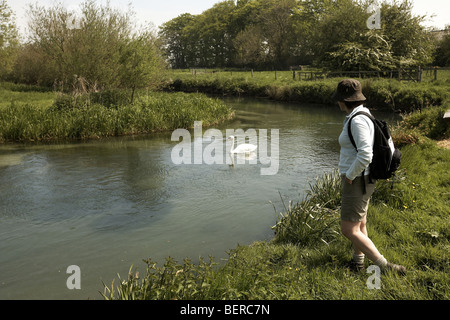 Walker on West Beck chalk stream river, Wansford, Driffield, East Yorkshire, UK Stock Photo