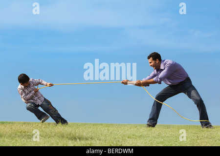 young men pulling rope and playing tug of war isolated on white