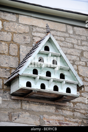 A SMALL DOVECOTE ON THE WALL OF A COTTAGE IN GLOUCESTERSHIRE UK Stock Photo