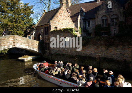 Bonifacius bridge over canal and tourists during sightseeing boat trip in Bruges, Belgium Stock Photo