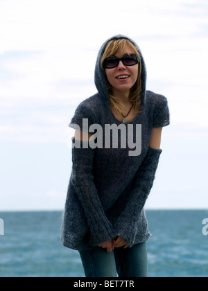 Blond Model in Hood Posing beach in Sunglasses Stock Photo