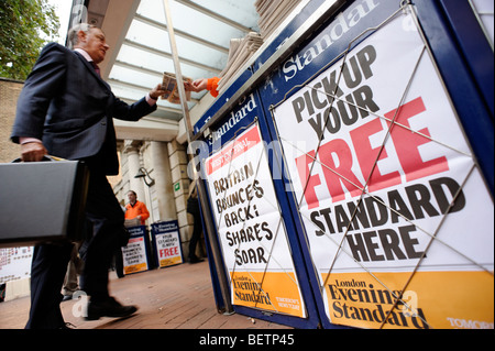 Person taking a free copy of the London Evening Standard newspaper. Central London. Britain. UK Stock Photo