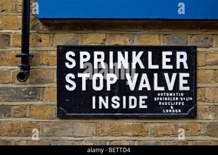 sprinkler stop valve inside sign on a brick wall in richmond upon thames, surrey, england Stock Photo
