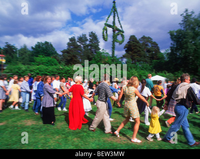 Dancing around Maypole during Midsummer Celebrations in Sweden on small island in Stockholm Archipelago Stock Photo