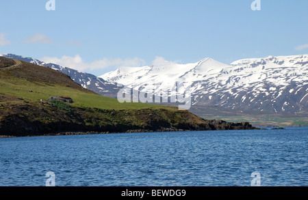 Rocky coast and snow-covered mountains in North Iceland, Grenivik, Iceland Stock Photo