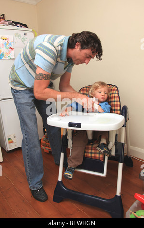Father trying to clean son's face after dinner Stock Photo