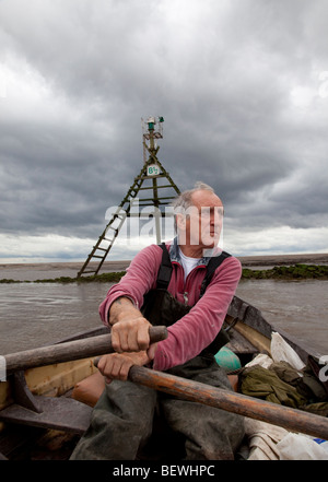 Commercial salmon fisherman rowing upstream the River Ribble Uk Stock Photo
