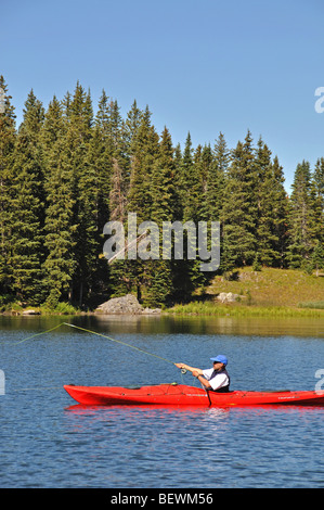 a sea kayaker fly fishing on an alpine lake high up in Colorado's San Juan mountains Stock Photo