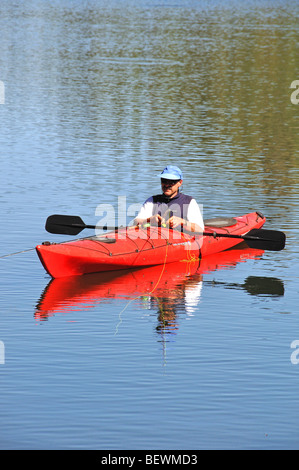 a sea kayaker fly fishing on an alpine lake high up in Colorado's San Juan mountains Stock Photo