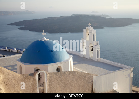 Greek white church with bell tower and blue dome, overlooking the sea, Santorini, Cyclades Islands, Greece. Stock Photo