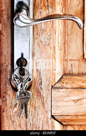 Set of keys in lock of old wooden door Stock Photo