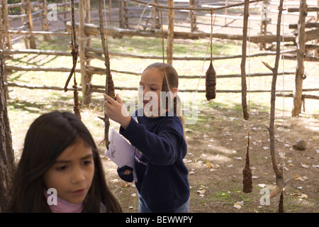 two girls looking at hand made candles hanging to dry, Los Golondrinas, New Mexico, USA Stock Photo