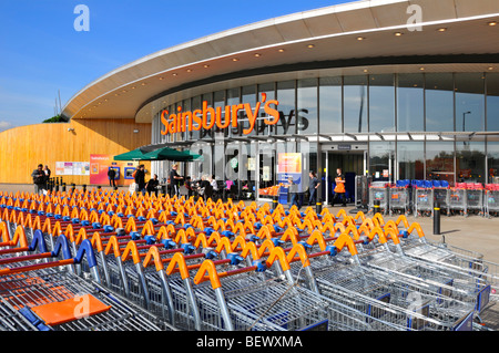 Sainsburys supermarket business retail shop front trolley cart park and store entrance with Starbucks coffee shop Greenwich London England UK Stock Photo